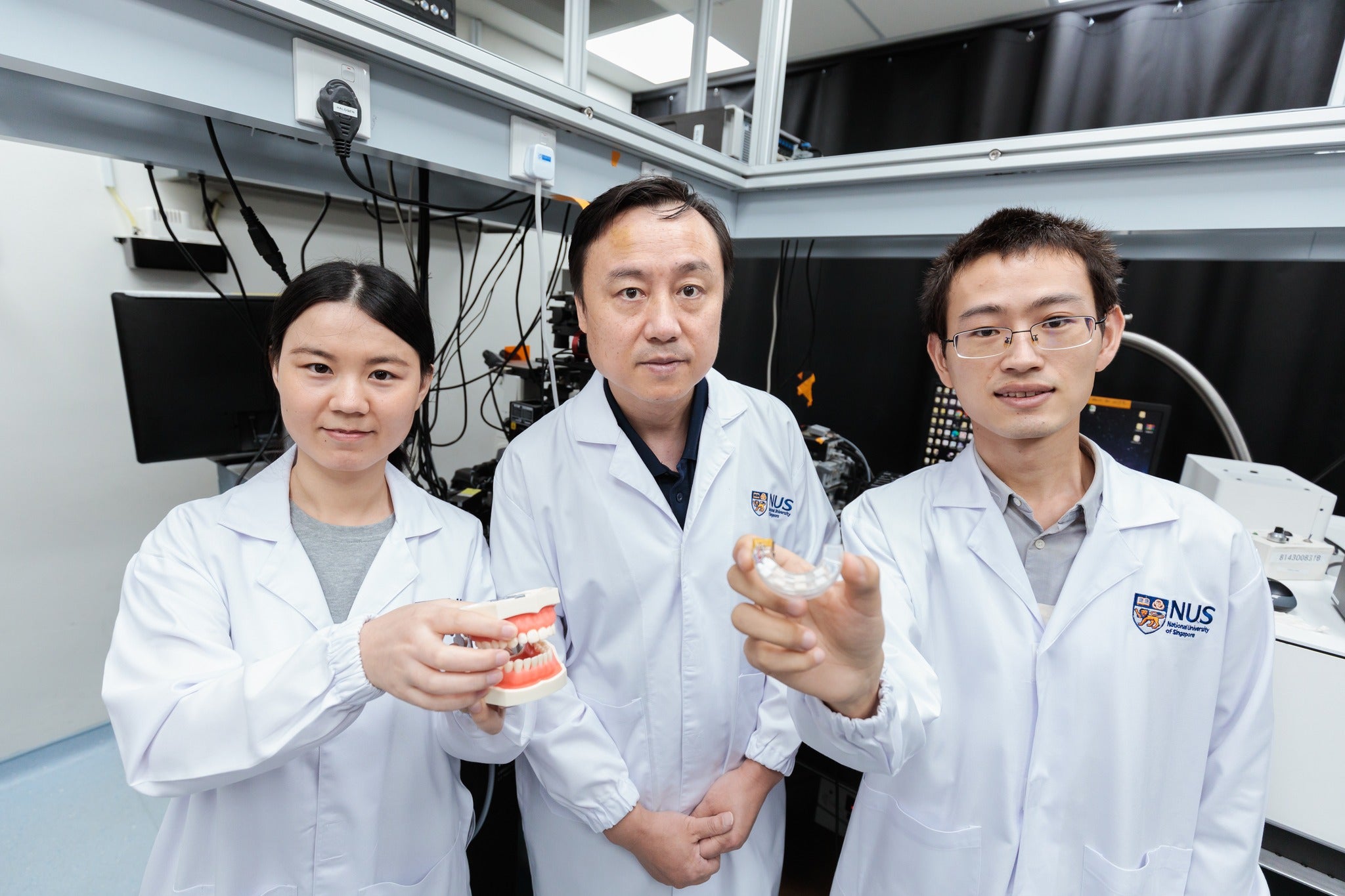 An NUS research team led by Prof Liu Xiaogang (centre) has created a revolutionary mouthguard that uses bite force to operate electronic devices such as computers, smartphones and even wheelchairs with high accuracy.